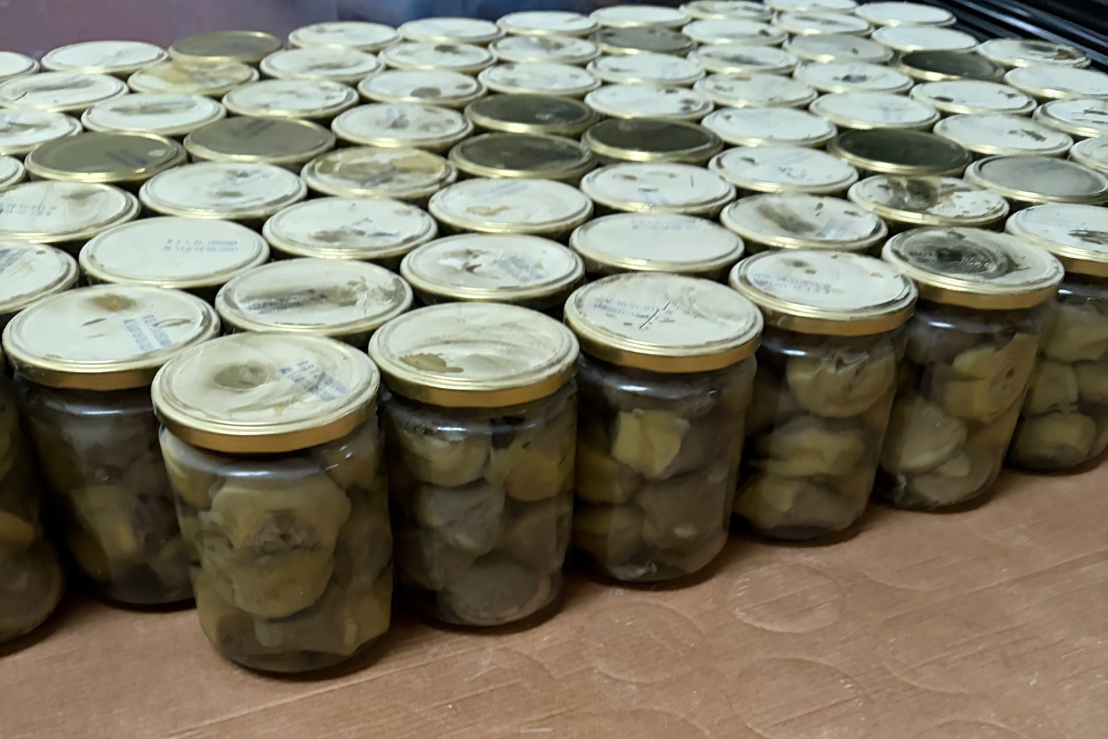 Pallet de tarros de alcachofa de Navarra apilados sobre cartón, listos para distribución