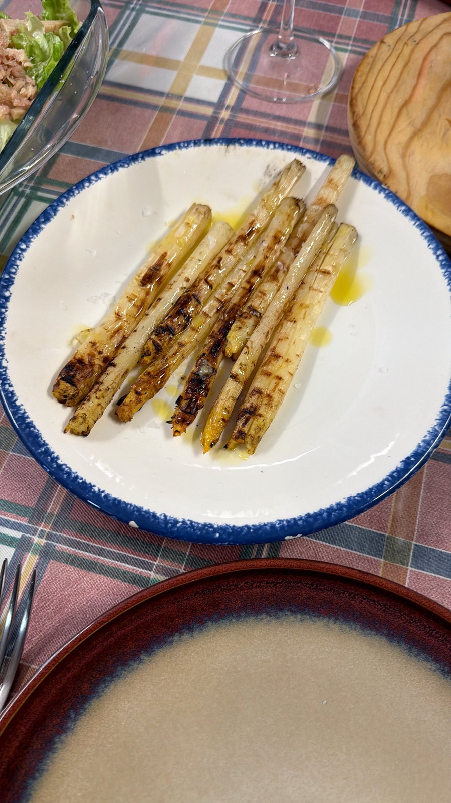Espárragos blancos de Navarra a la brasa en plato cerámico, aceite de oliva y escamas de sal